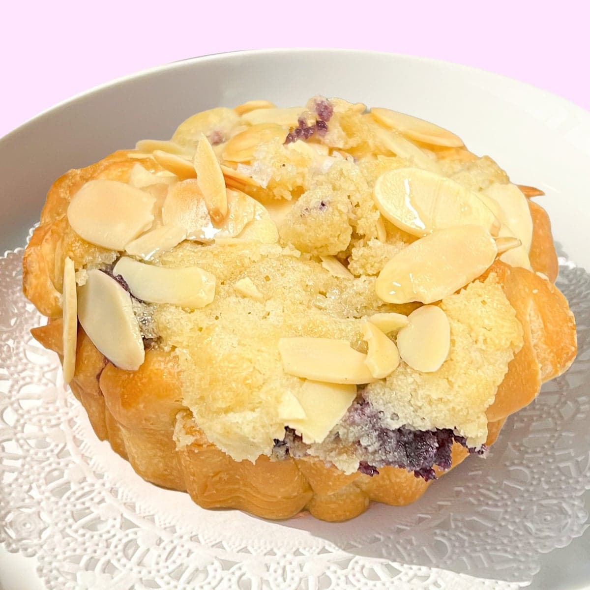A blueberry almond croissant tart covered in toasted sliced almonds
