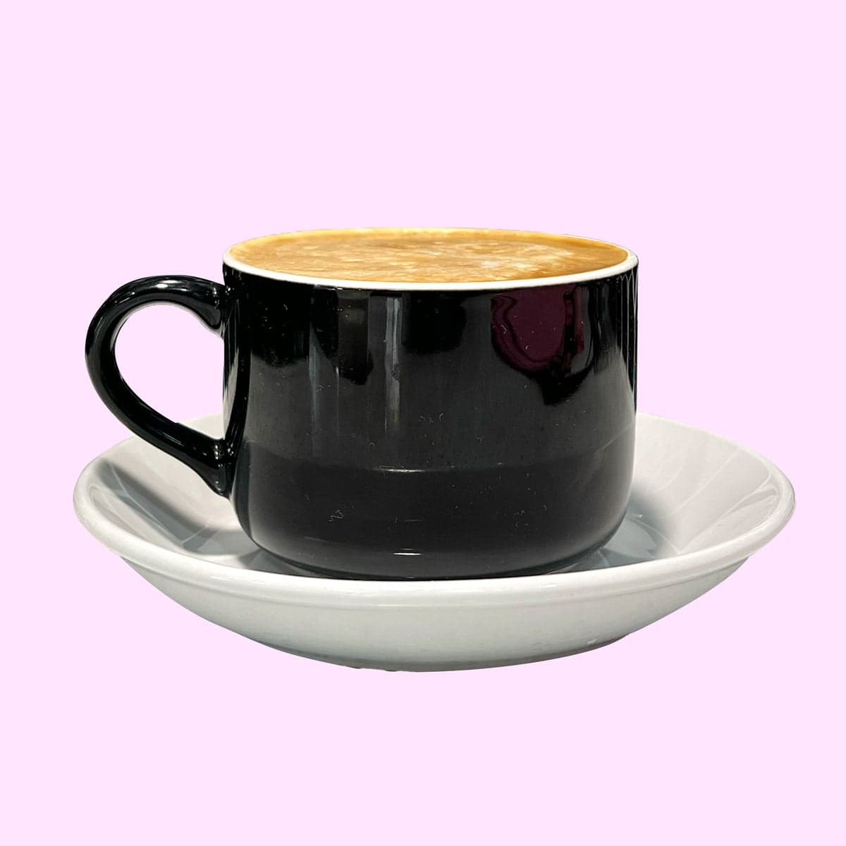 A cappuccino poured with a leaf in the foam