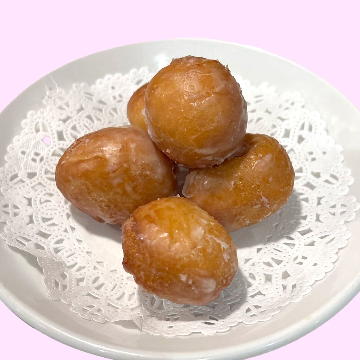 Three doughnut holes on a paper doily