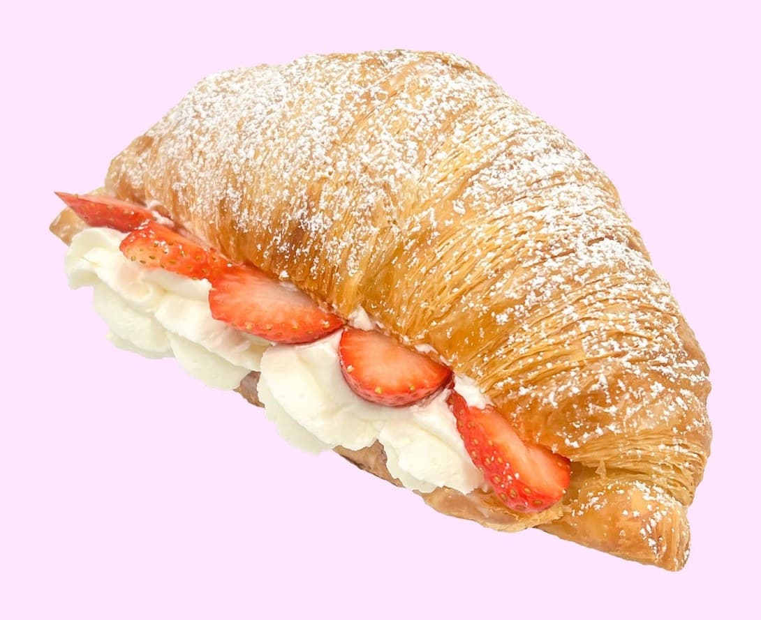 A Fresas con Crema croissant from Viva La Fresa, split and filled with vanilla cream and fresh sliced strawberries, dusted with powdered sugar