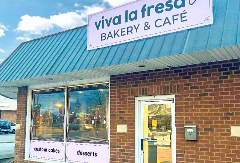 The Viva La Fresa storefront on South Lowry Street, a brick building with a teal awning and a blush sign reading viva la fresa bakery and café